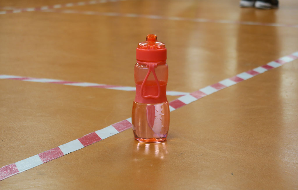 botella de agua en el suelo de un gimnasio