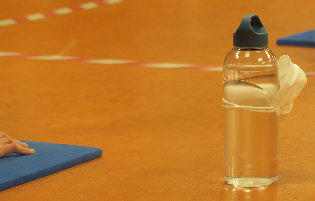 botella de agua y mascarilla en el gimnasio