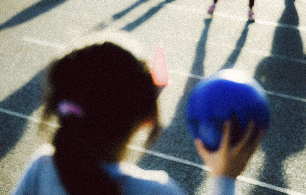 niña jugando con un balón en el parque
