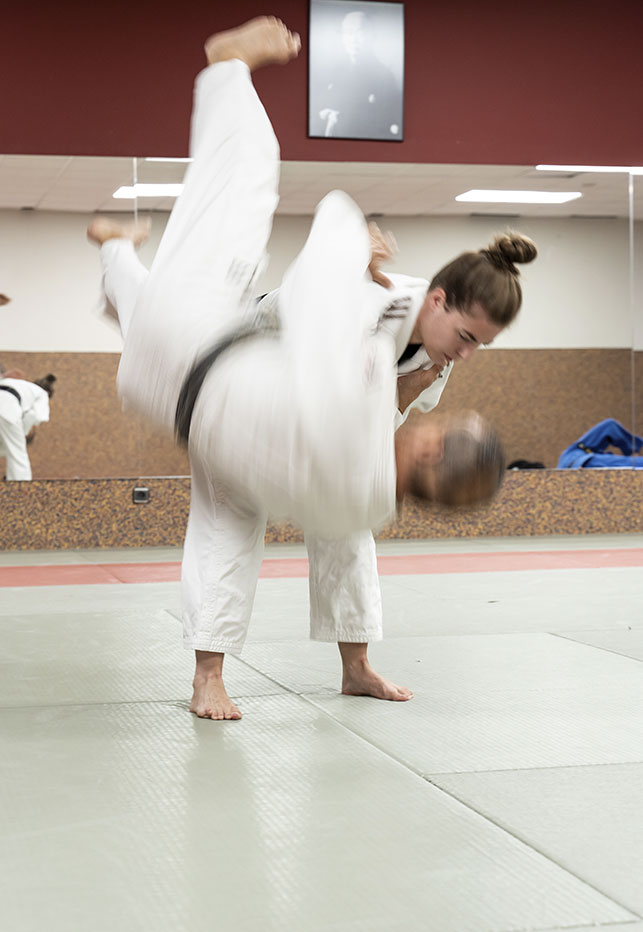 alumna haciendo una llave de judo al profesor de judo