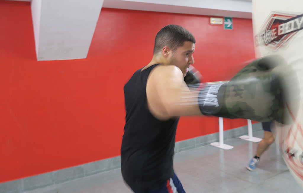 un hombre pega un puñetazo al saco de boxeo