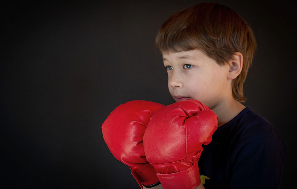 un niño con dos guantes rojos de boxeo