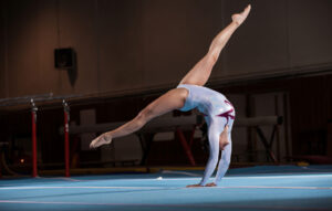 gimnasta hace una acrobacia de suelo en el tapiz