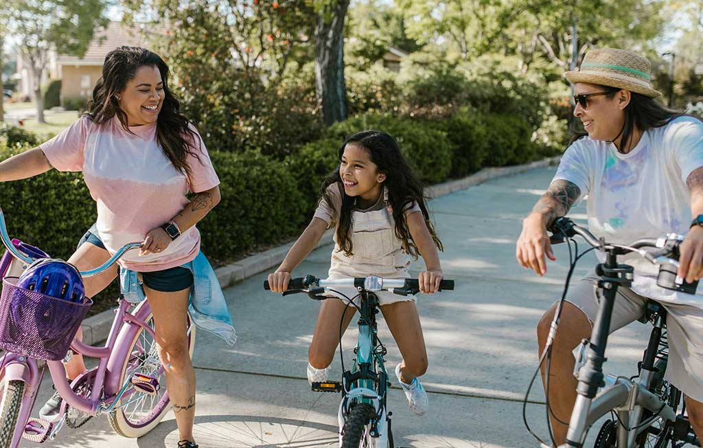 familia ríe dando un paseo en bicicleta