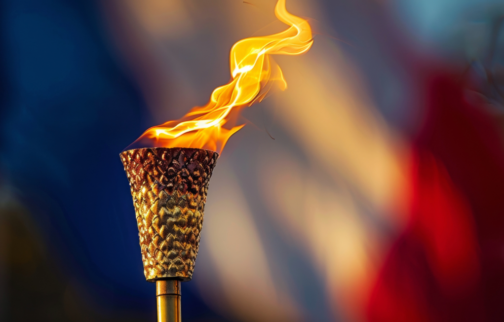 Antorcha olímpica ardiendo frente a la bandera de francia