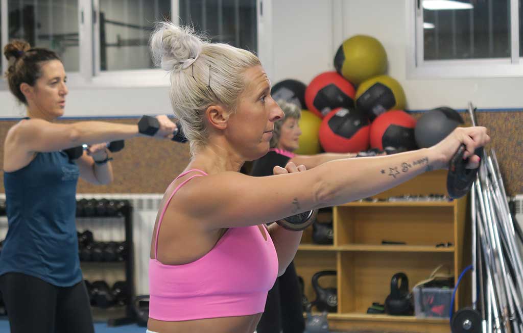 profesora de abdominales exprés hace un ejercicio en clase