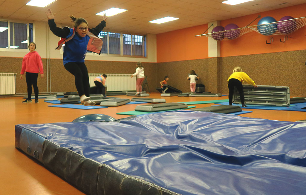 alumna de gimnasia artística saltando hacia colchoneta.