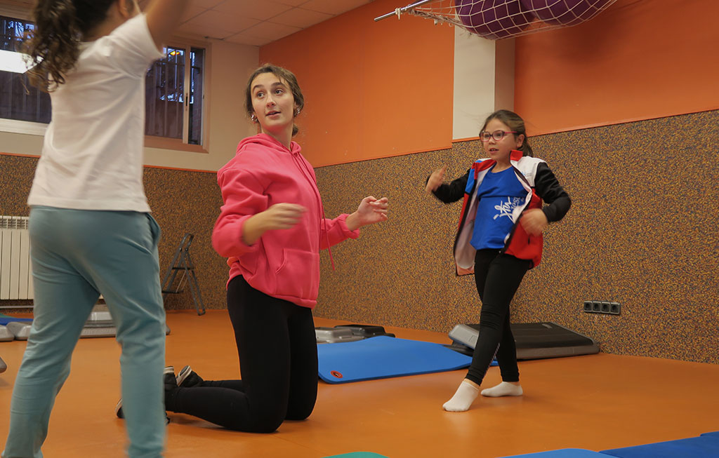 Entrenadora de gimnasia artística y alumnos.