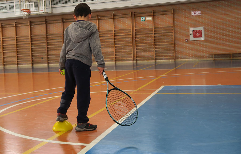 Niño y raqueta de tenis.