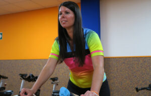 mujer pedaleando en una bici de spinning del gimnasio