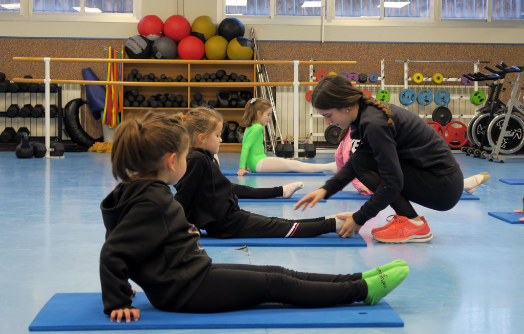 Profesora y alumnas en clase de gimnasia rítmica